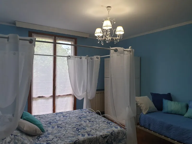 Camera Diamante con letto matrimoniale a baldacchino, tende bianche e pareti azzurre