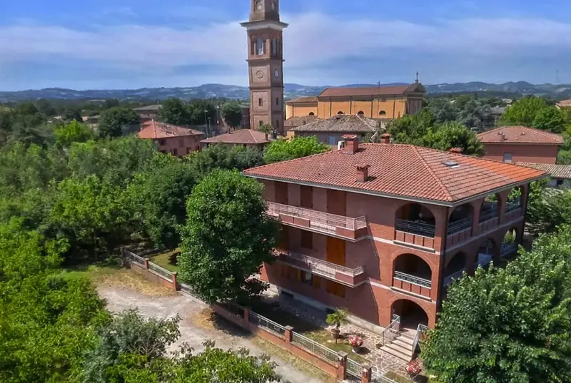 Facciata in mattoni di Villa Ferrari Oriella con giardino